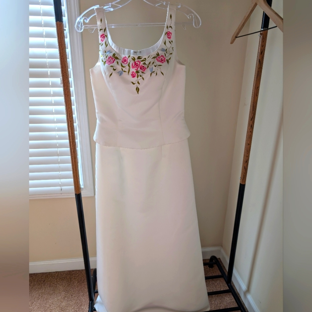 White dress with flower embroidery on the neckline.